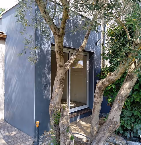 Extension moderne de maison avec larges baies vitrées donnant sur le jardin